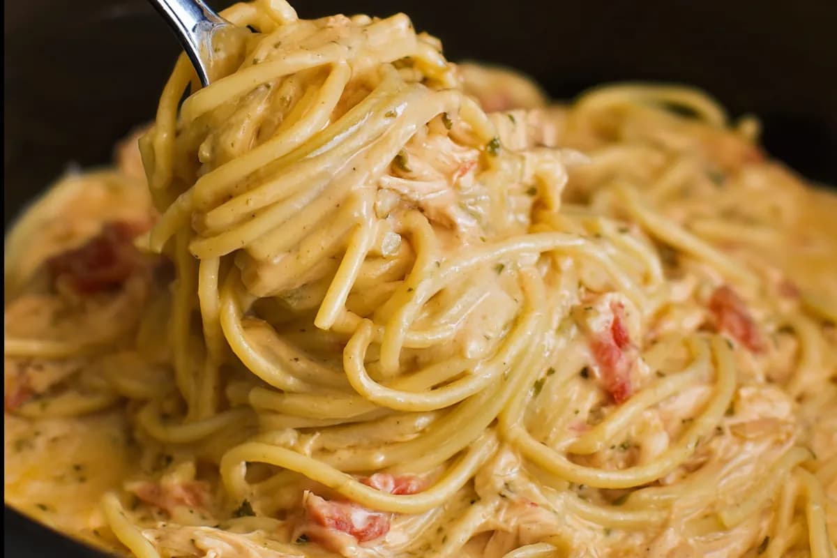 Creamy crockpot chicken spaghetti with melted cheese and tender chicken