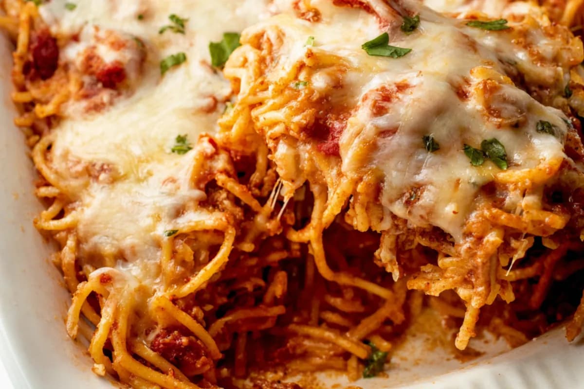 Baked spaghetti casserole topped with melted cheese, perfect Thanksgiving side dish.