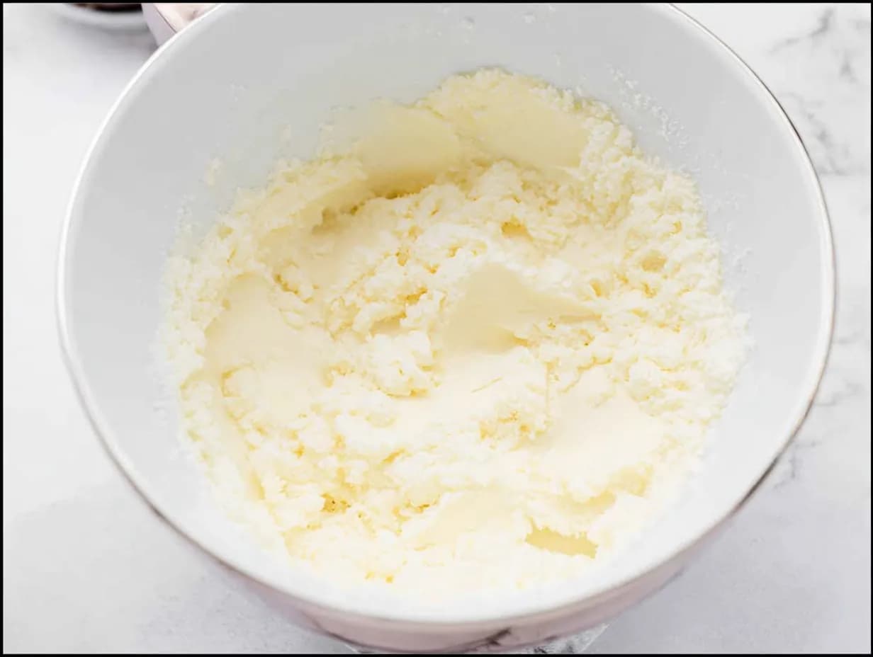 Creamed butter and sugar in a white mixing bowl for vanilla buttermilk pound cake.