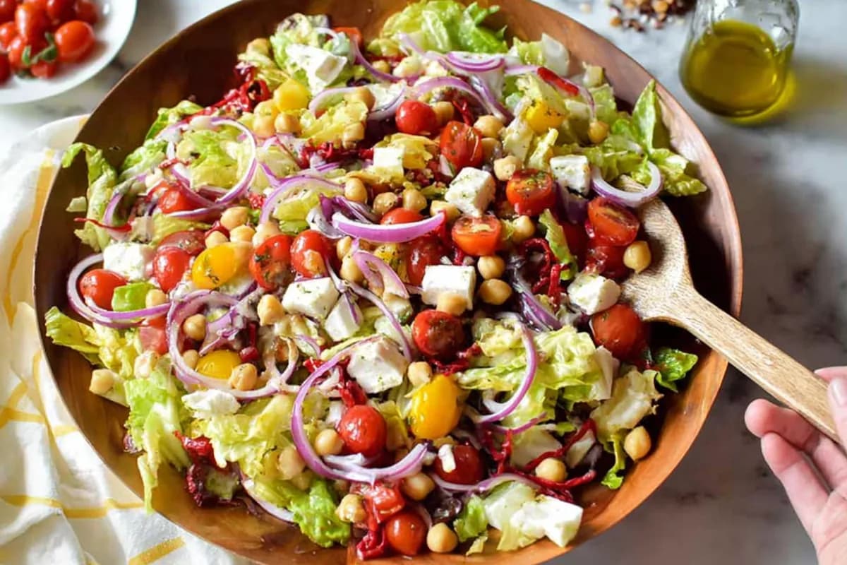 Italian chopped salad with lettuce, cherry tomatoes, chickpeas, mozzarella, and red onion
