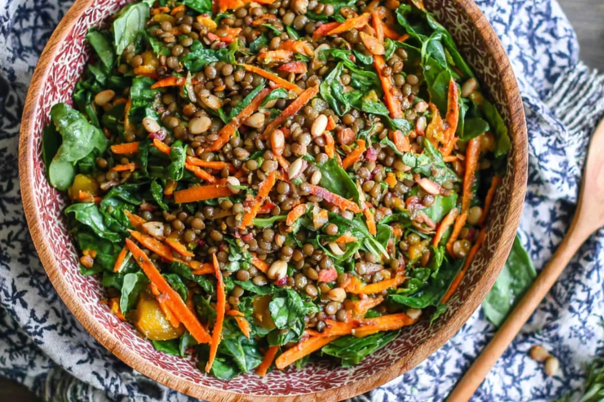Moroccan lentil carrot salad in a rustic bowl with greens and nuts