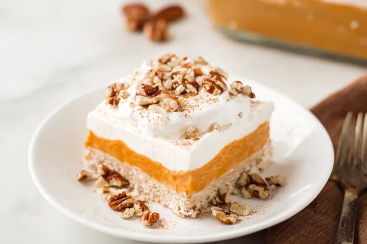 Pumpkin delight dessert slice with whipped topping and pecans