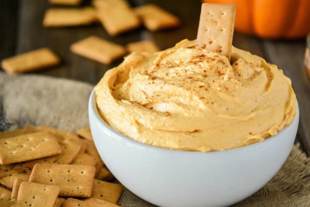pumpkin fluff dip served in white bowl with graham crackers